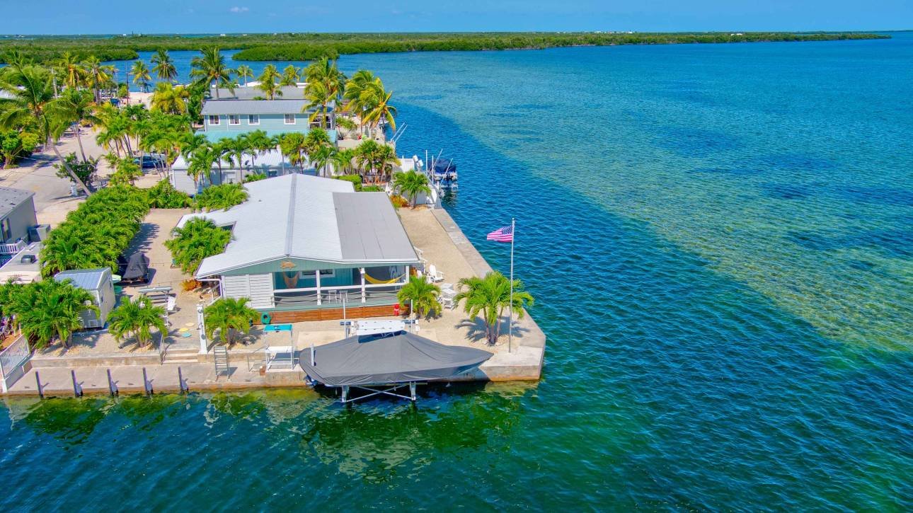 Coastal house with vibrant blue water and lush greenery