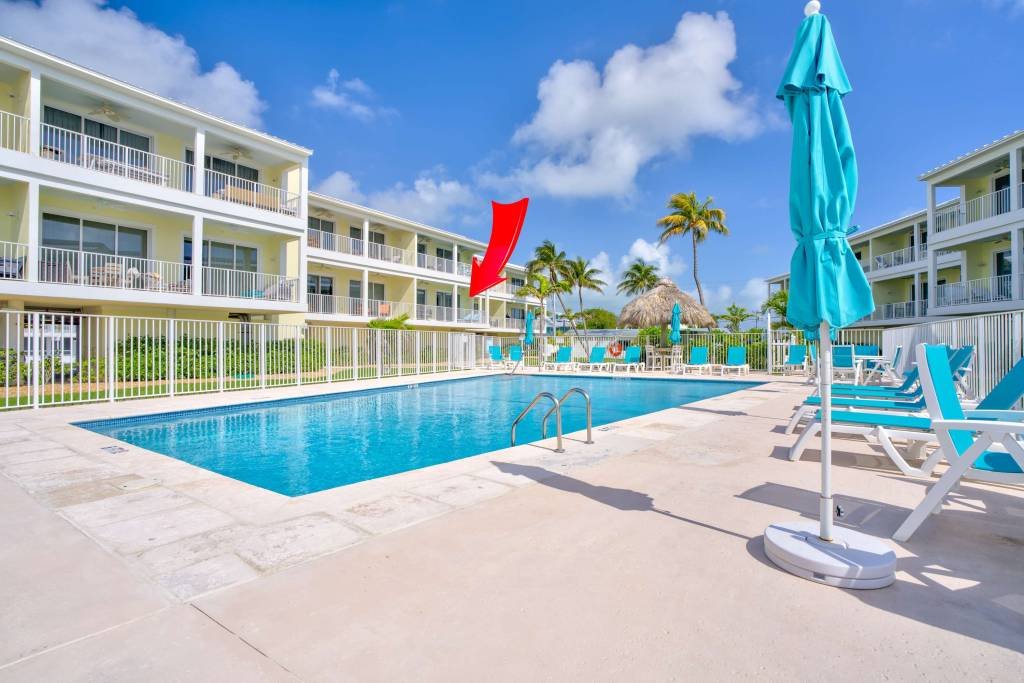 Resort swimming pool with blue umbrellas and lounge chairs
