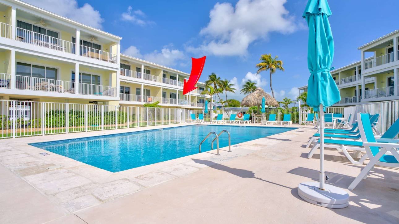 Resort swimming pool with blue umbrellas and lounge chairs