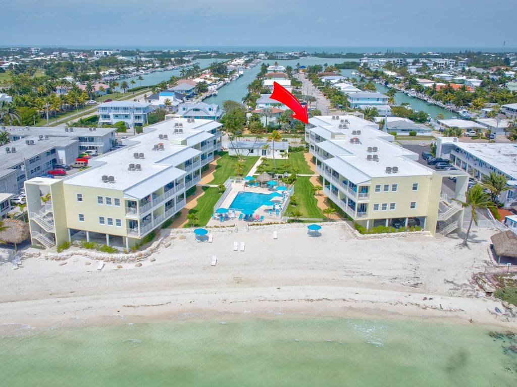 Aerial view of waterfront resort with pool and beach access
