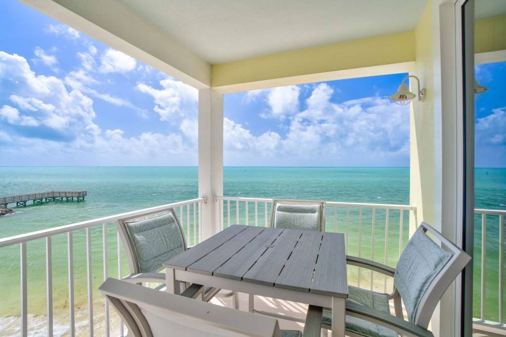 Oceanfront balcony with chairs and table overlooking the sea