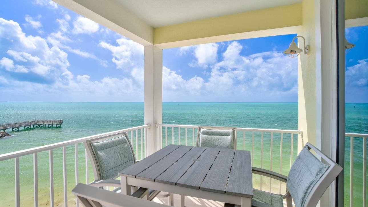Oceanfront balcony with chairs and table overlooking the sea