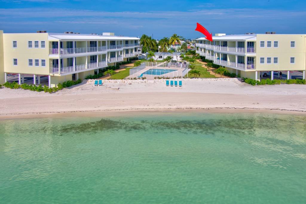 Beachfront resort with pool and ocean view under blue sky