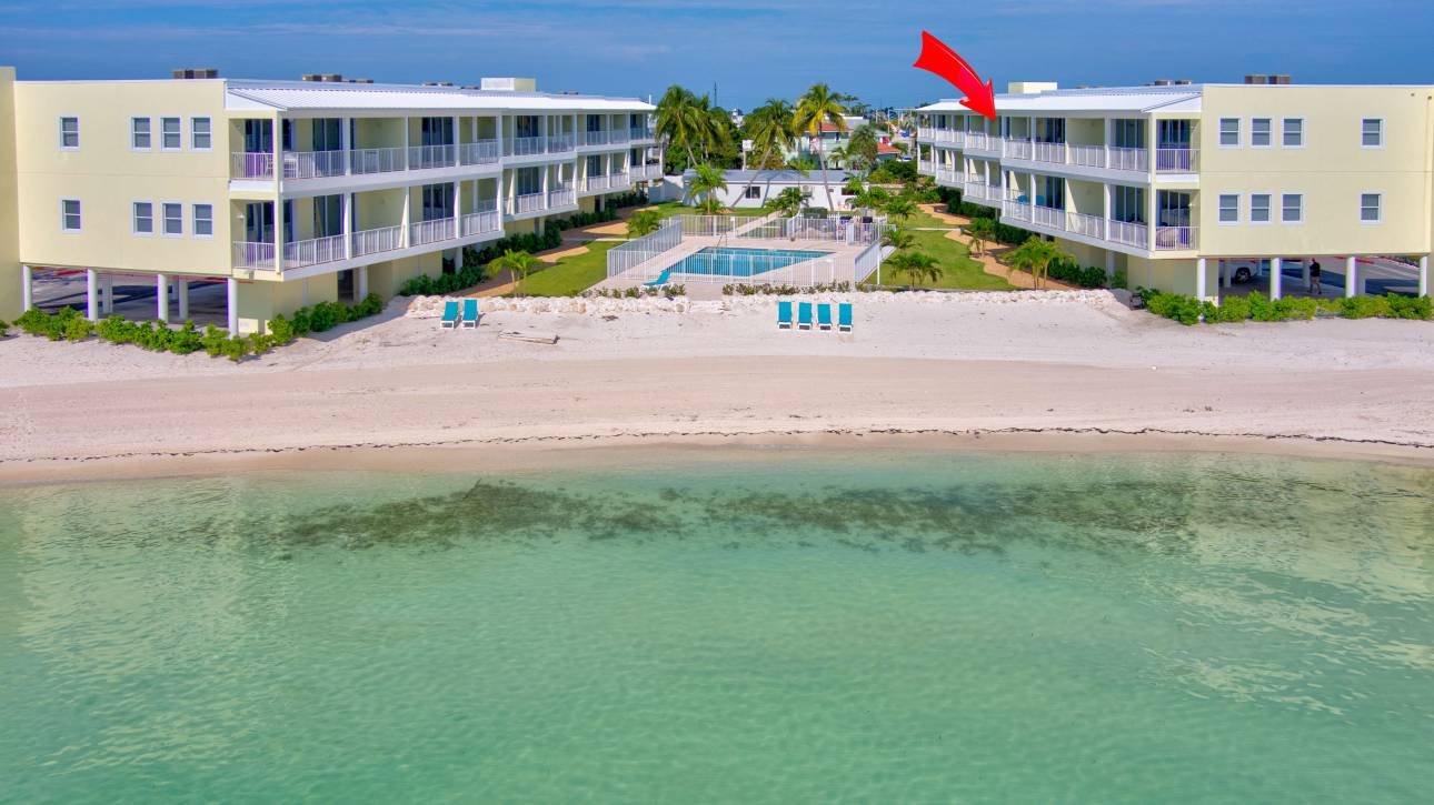 Beachfront resort with pool and ocean view under blue sky