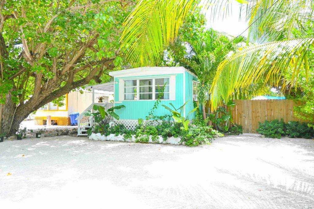 Colorful tropical beach hut surrounded by lush green palm trees